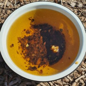 bowl of honey bee propolis, water and floating debris