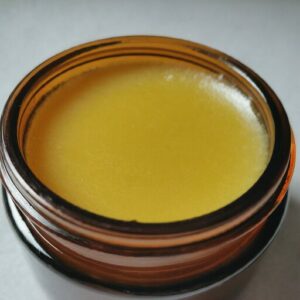 honey bee propolis salve in a dark glass jar