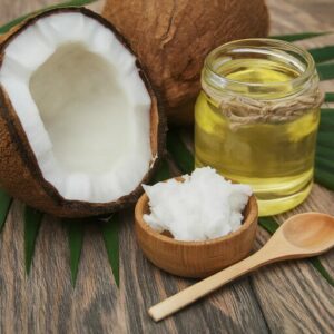 broken coconut with oil and a wooden spoon