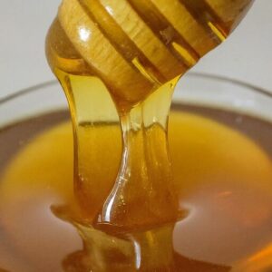 honey dripping from a wooden honey dipper